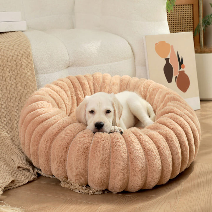 Cream-colored round pet donut bed, a plush and comfortable calming dog bed.