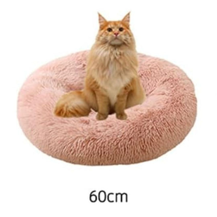 Cute cat sleeping soundly in a comfortable, deep plush calming pet bed