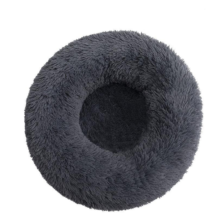 Small pet snuggled in a cozy plush donut bed, demonstrating comfort