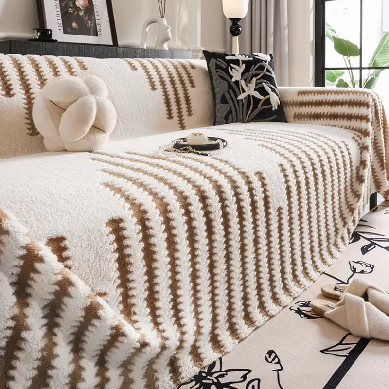 Plush sofa couch cover in a neutral color, providing full coverage protection for living room furniture