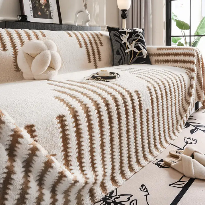 Plush sofa couch cover in a neutral color, providing full coverage protection for living room furniture