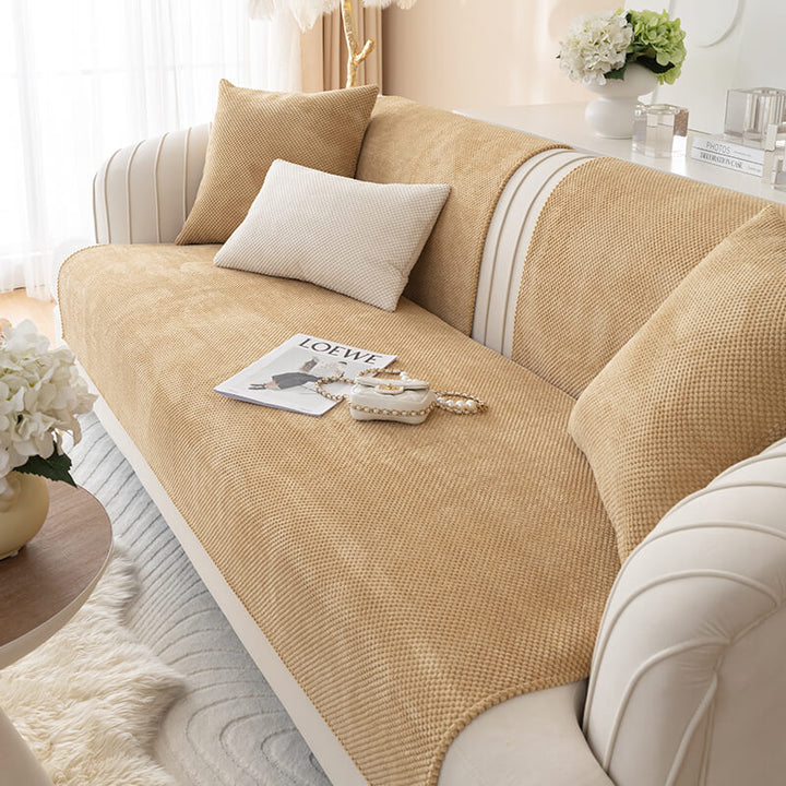 Non-slip plush solid color couch protector covering a sectional sofa with armrests