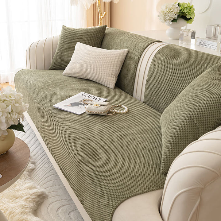 High-angle view of a plush solid color sofa cover neatly fitted on a modern couch, home decor