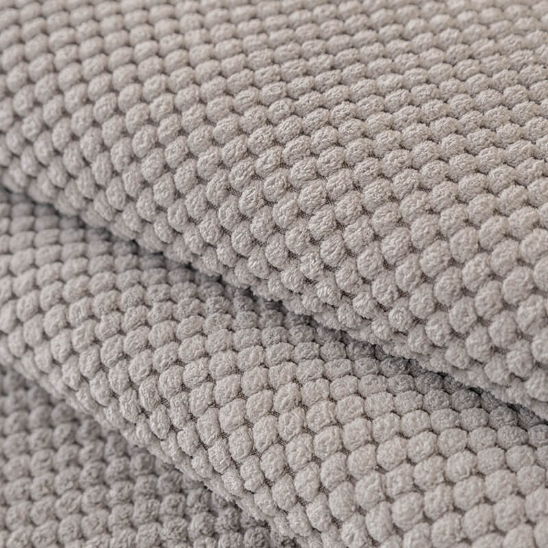 Plush solid color sofa cover in a neutral tone, blending seamlessly with living room decor