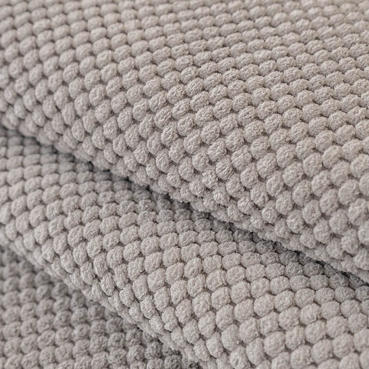 Plush solid color sofa cover in a neutral tone, blending seamlessly with living room decor