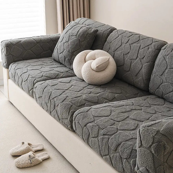 Living space with a comfortable sofa featuring a plush stone-textured stretch cover, ideal for families