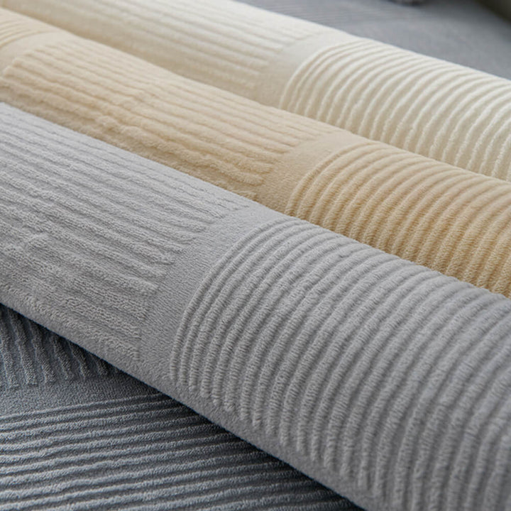Plush striped square couch cover draped over a large sectional sofa, full view.