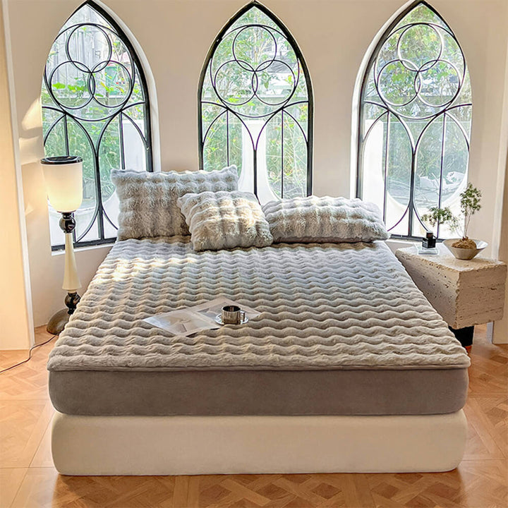 Top-down view of a bed dressed with a plush bubble fitted sheet and matching pillowcases, cozy bedroom decor.