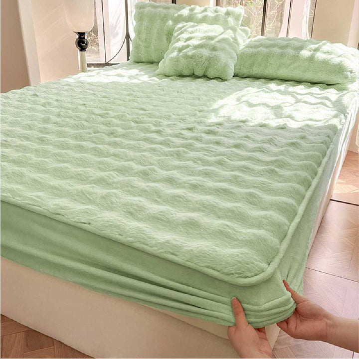 Detailed shot of the elasticized edge of the plush fitted sheet, showcasing its secure fit on a mattress.