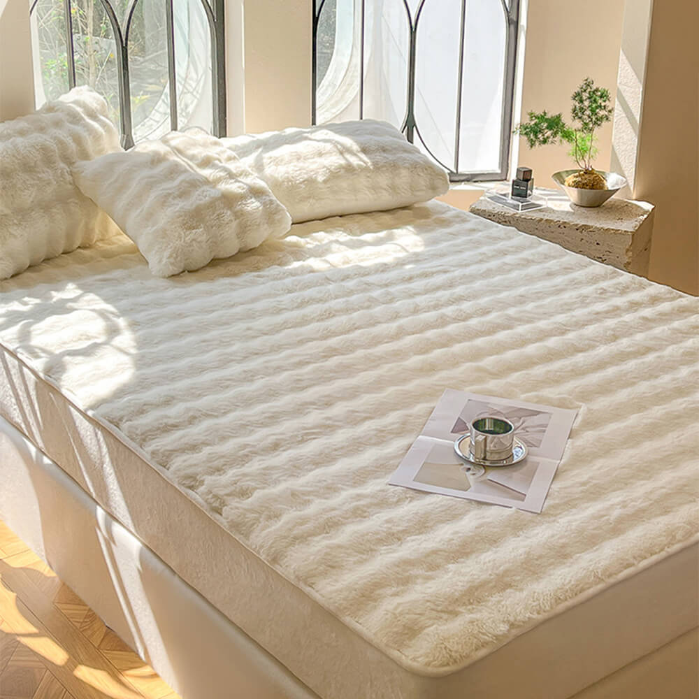 Stack of folded plush bubble fitted sheets and pillowcases, showing the rich velvet fabric for a cozy home.