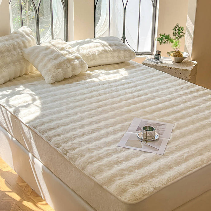 Stack of folded plush bubble fitted sheets and pillowcases, showing the rich velvet fabric for a cozy home.