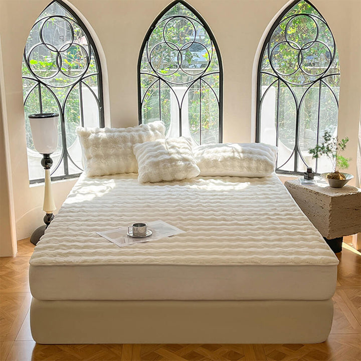 Unisex bedding set: plush fittedsheet & pillowcases in a bedroom, featuring a soft velvet mattresscover.