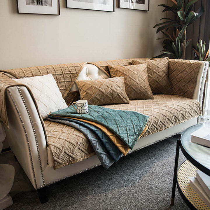 Machine washable velvet quilted couch cover draped over a sofa, emphasizing furniture protection.
