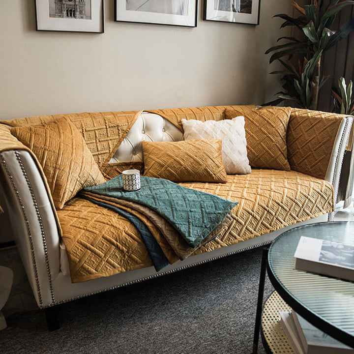 A stylish quilted velvet couch cover, perfect for home decor and easy maintenance, shown on furniture.