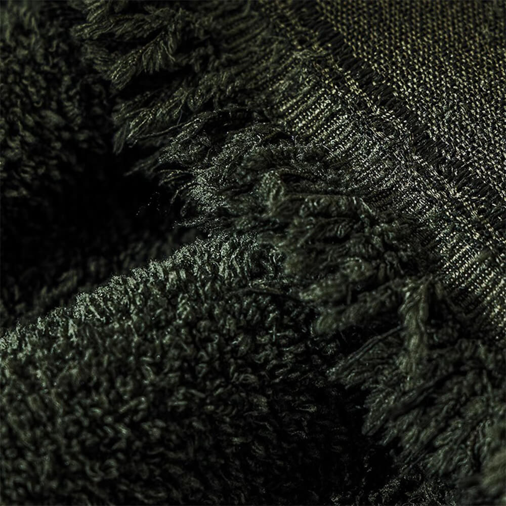 Detail view of elastic straps securing a plush water-resistant sofa protector to the couch.