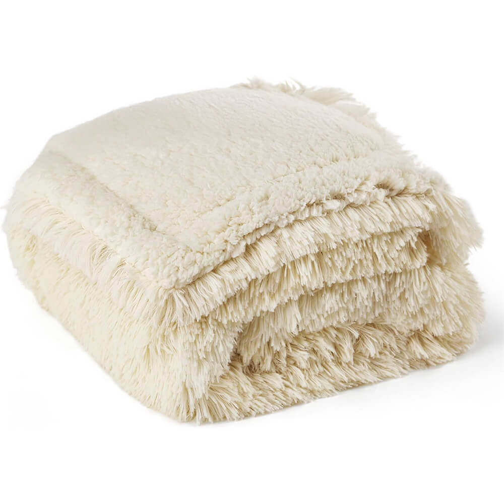 Puppy playfully tugging at a corner of a durable, waterproof plush pet throw blanket