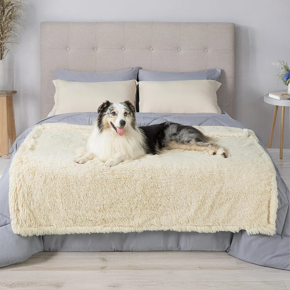 Happy dog napping comfortably on a plush, waterproof pet throw blanket on a wooden floor
