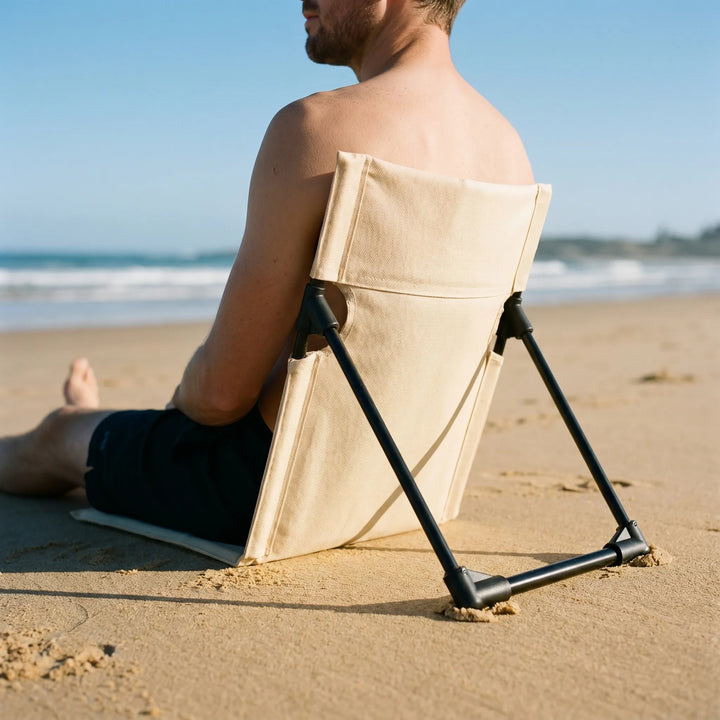 Portable folding floor chair for outdoor seating, ideal for camping, picnics, or beach trips.
