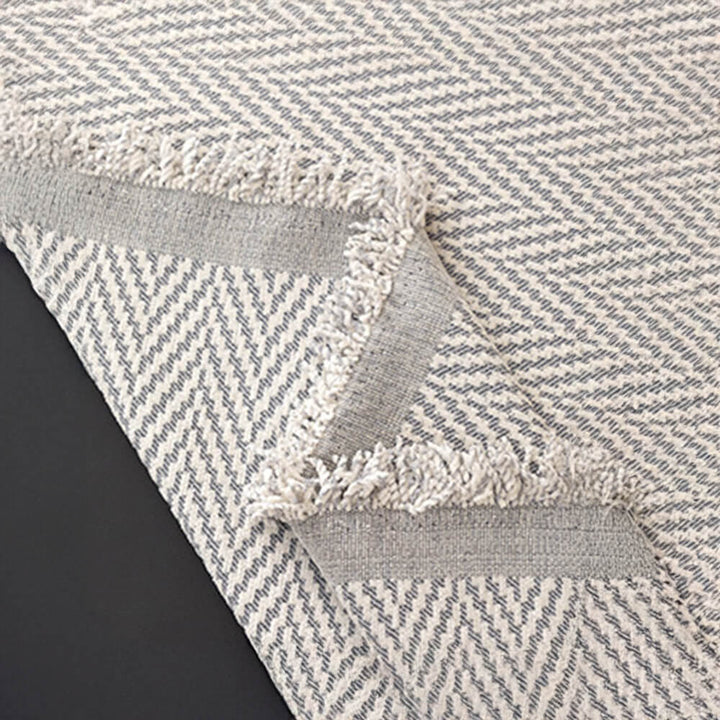 Modern herringbone chenille couch cover with tassel fringe for stylish comfort.