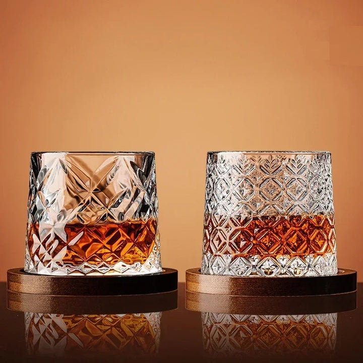A hand holding a premium crystal whiskey glass filled with amber spirits. Elegant barware experience.