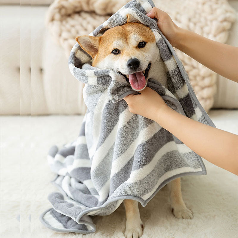 Quick-dry coral fleece pet bathrobe for dogs, featuring adjustable strap, displayed on a wooden floor.