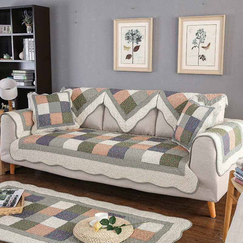 Non-slip quilted couch cover in durable cotton blend, washable, protecting sofa in a living room.