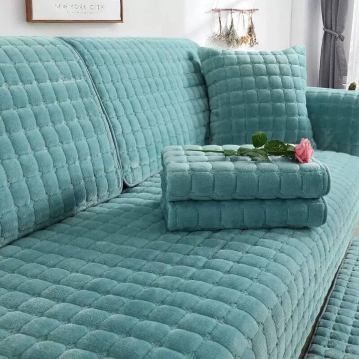 Anti-slip flannel sofa cover draped over a couch, quilted design, robust furniture protection.