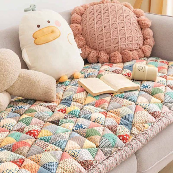 Close-up of quilted floral pattern on a cotton non-slip sofa protector, showcasing texture and detail.