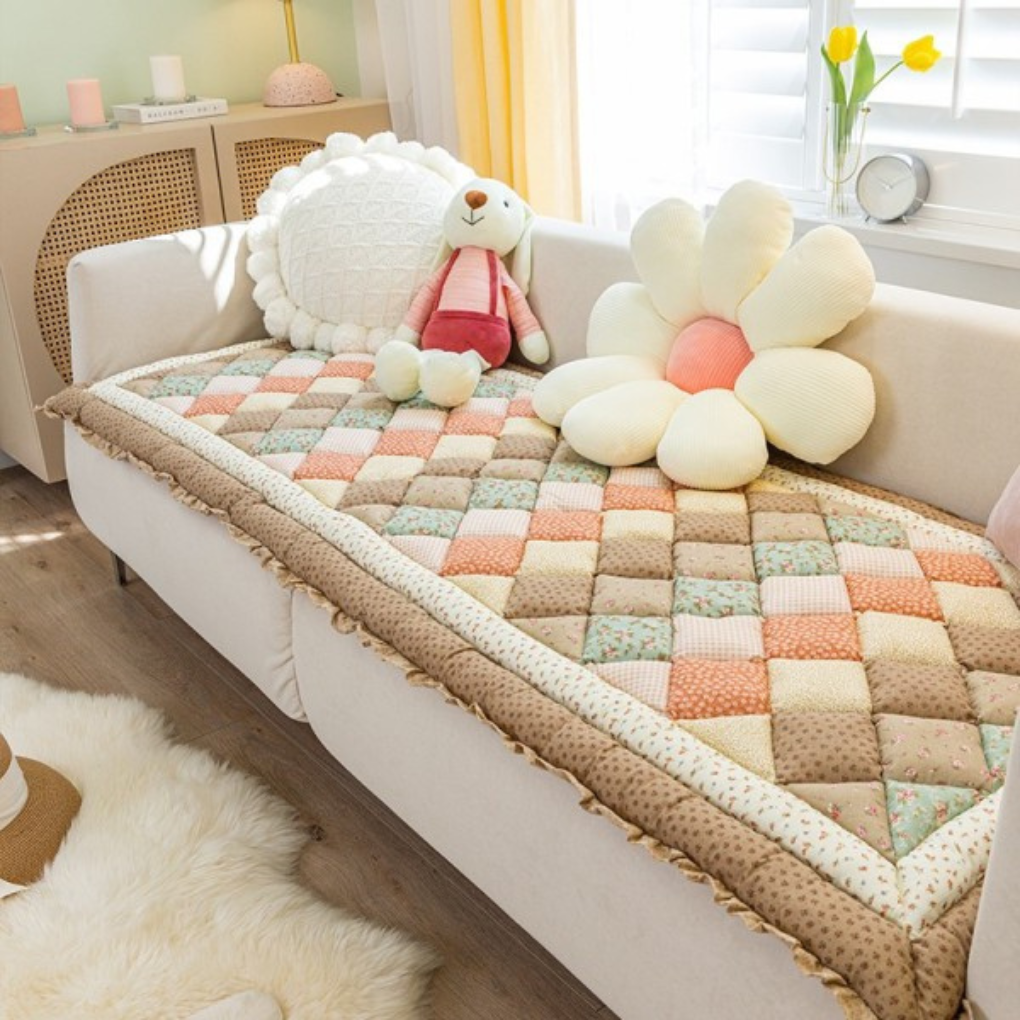 Elegant quilted floral non-slip sofa cover enhancing the aesthetic of a modern living room setting.