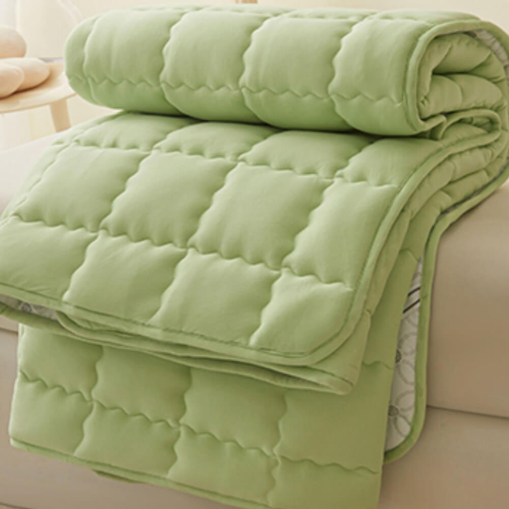 Elastic straps securing breathable quilted mattress topper to bed, non-slip
