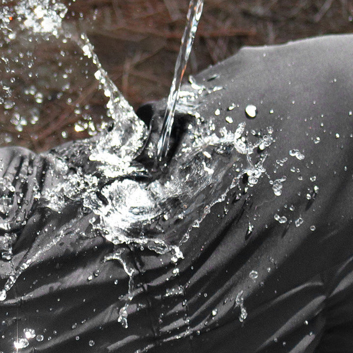 Close-up of the breathable fabric on the black waterproof dog coat, pet apparel detail.