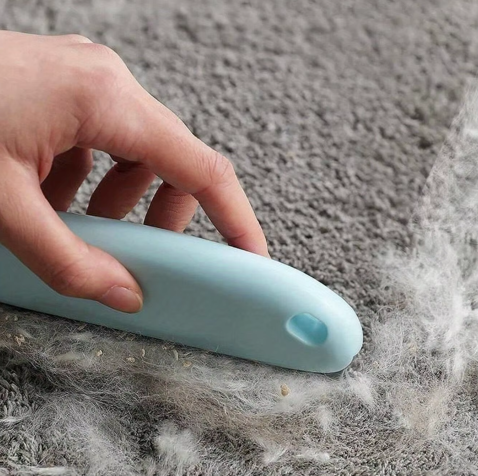 Reusable pet hair remover effectively lifts fur from a dark sofa, showcasing its cleaning power for furniture.