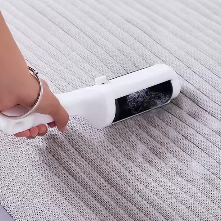 Reusable pet hair remover glides effortlessly over green sofa, perfect for dog and cat owners.