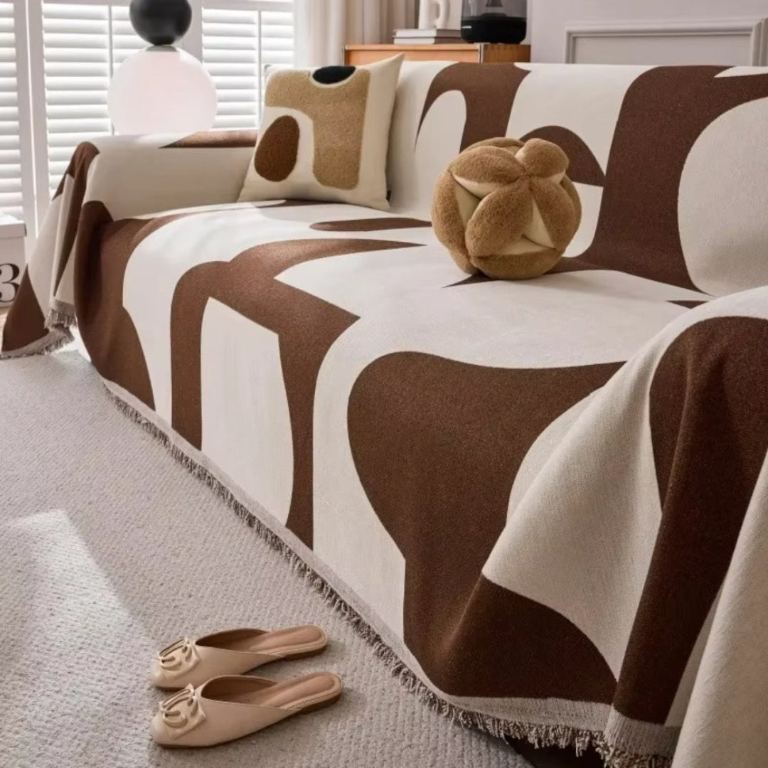 Reversible chenille sofa cover with decorative tassels, a durable and pet-friendly furniture protector for home decor.