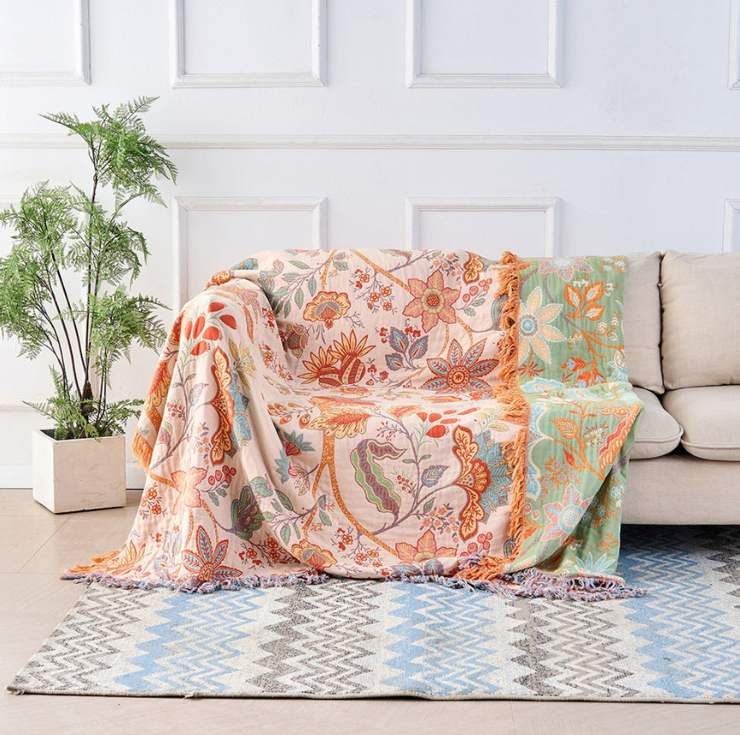 Close-up of rustic floral pattern on reversible throw blanket with decorative tassels