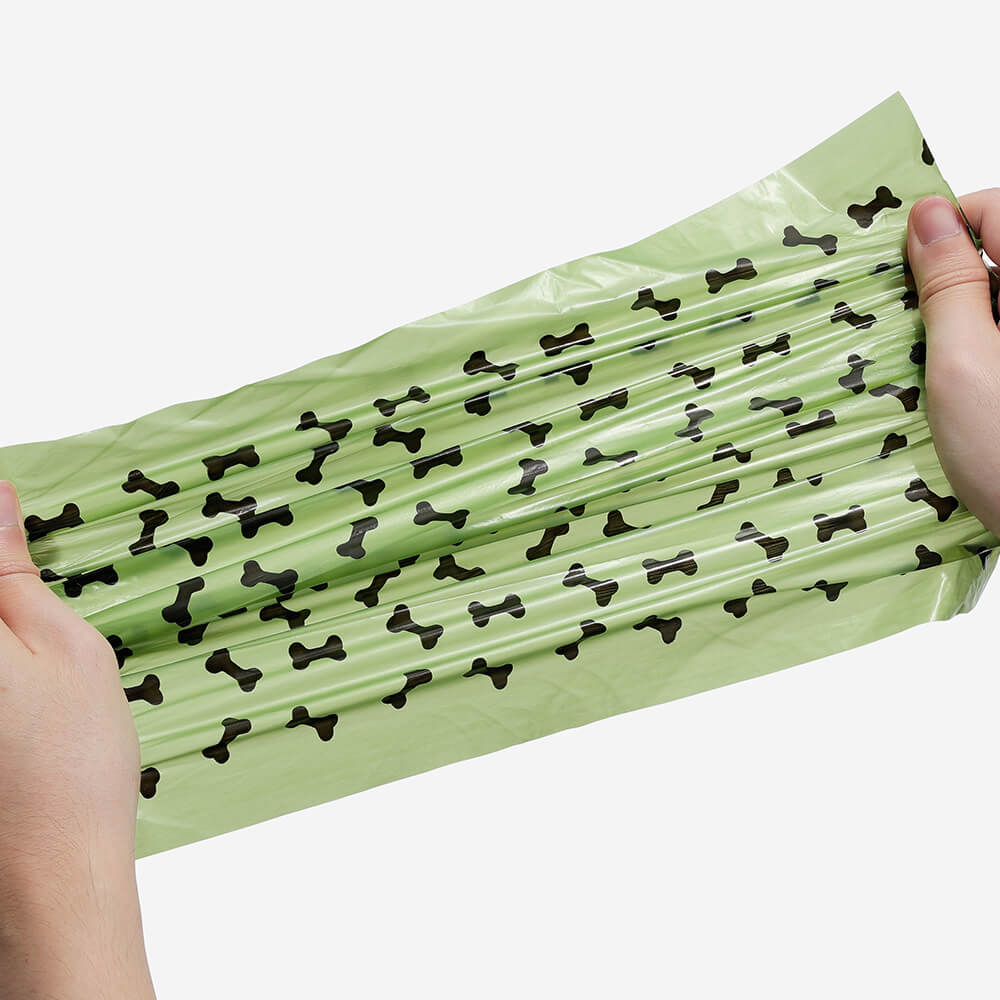 Hand holding a roll of scented biodegradable dog waste bags, responsible dog walking