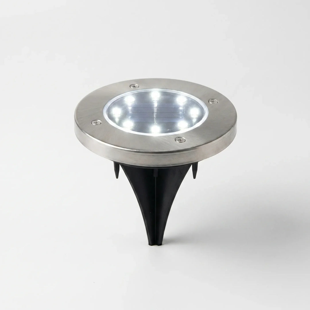 Easy-install wireless solar disk lights illuminating a garden pathway. Durable, waterproof LED ground lights for outdoor use.