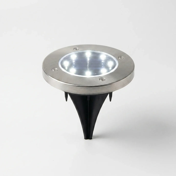 Easy-install wireless solar disk lights illuminating a garden pathway. Durable, waterproof LED ground lights for outdoor use.