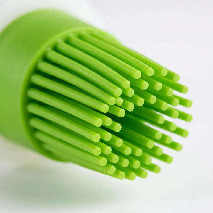 Kitchen dispensing silicone basting brush for precise application of marinades on BBQ and oil on pastries.