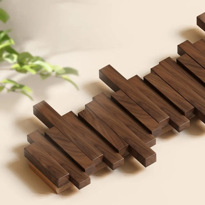 Space-saving folding wood coat rack. Wall-mounted natural wood hanger for modern entryway organization.