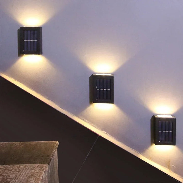 Stylish black solar LED wall light fixture enhances patio decor, providing bright, wireless outdoor security lighting.