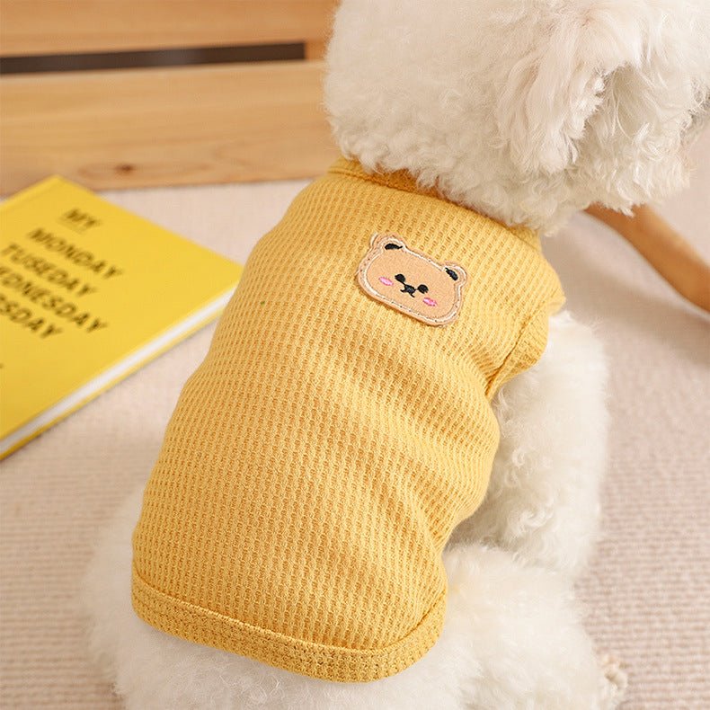Small dog wearing a cozy beige waffle knit dog vest, perfect for autumn pet apparel.