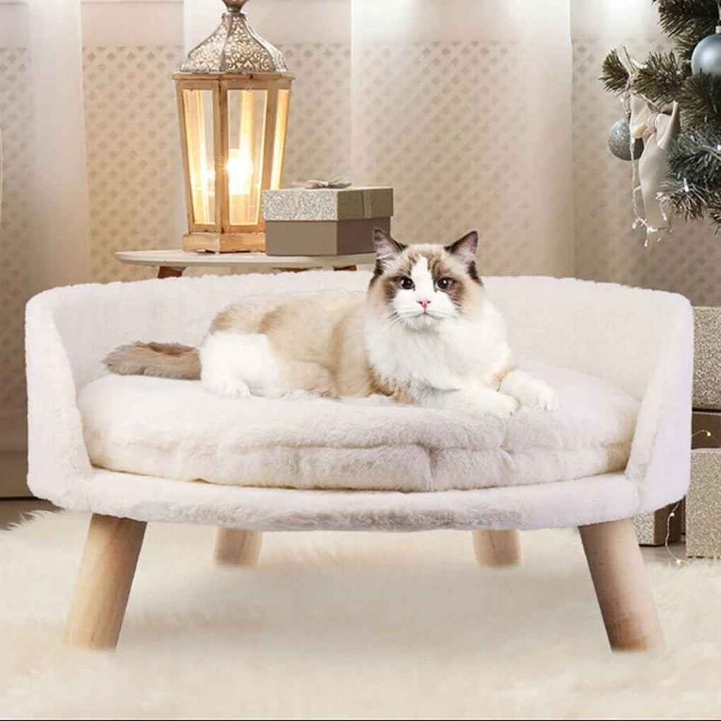 Round bolster pet bed for small dogs & cats, featuring soft plush fabric and stylish elevated wooden legs.