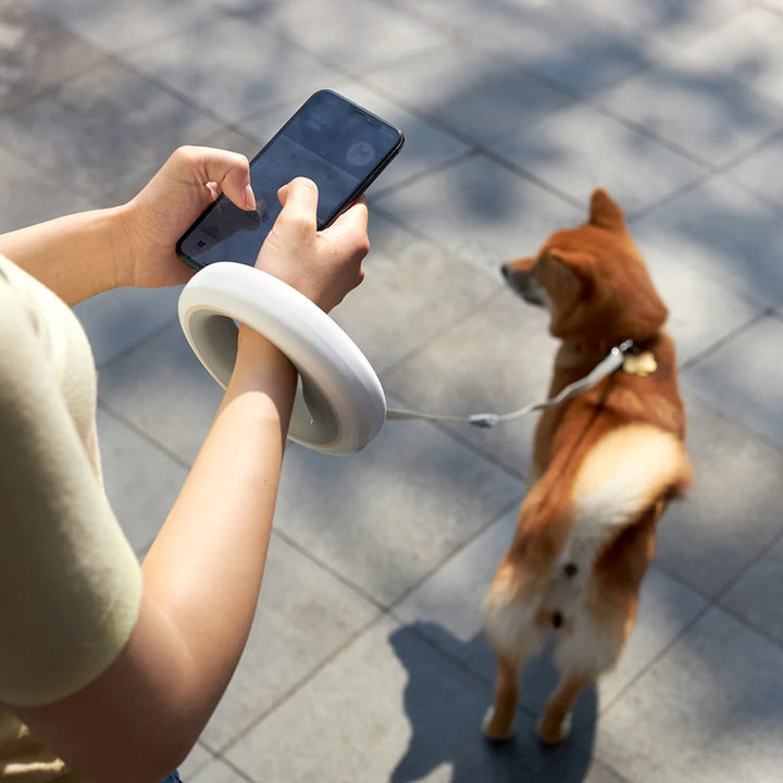 Ergonomic retractable dog leash in a vibrant color, showcasing its smart functions and comfortable hold for pet owners.