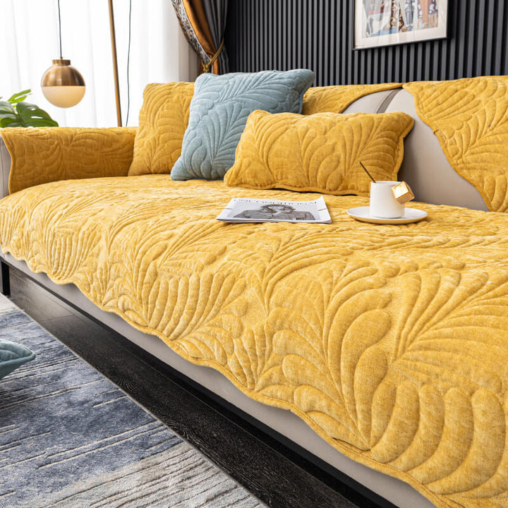 Non-slip cotton couch cover, featuring a stylish leaf design, fitting securely on a three-seater sofa.