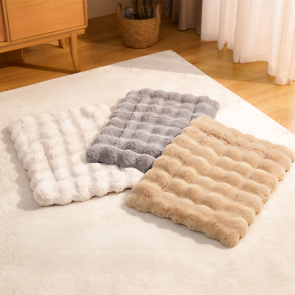 Dog relaxing on a soft faux rabbit fur mat with pillow, comfortable pet sleeping bed