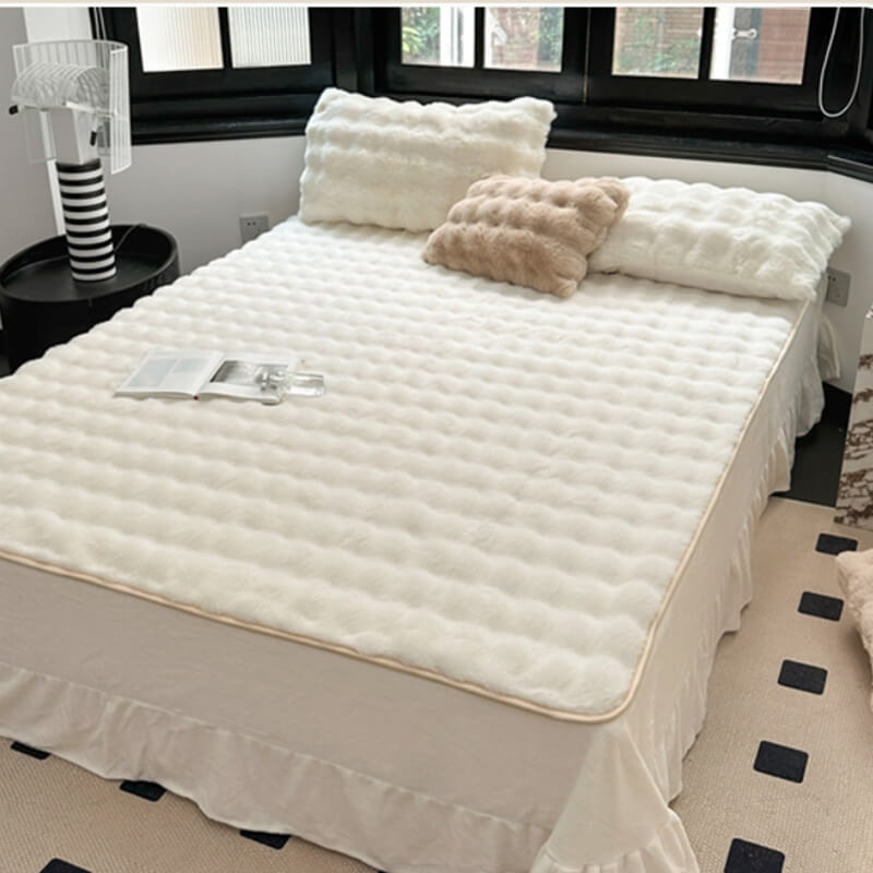 A person's hand touching the soft faux rabbit fur of a non-slip fitted mattress cover, bedding choice.