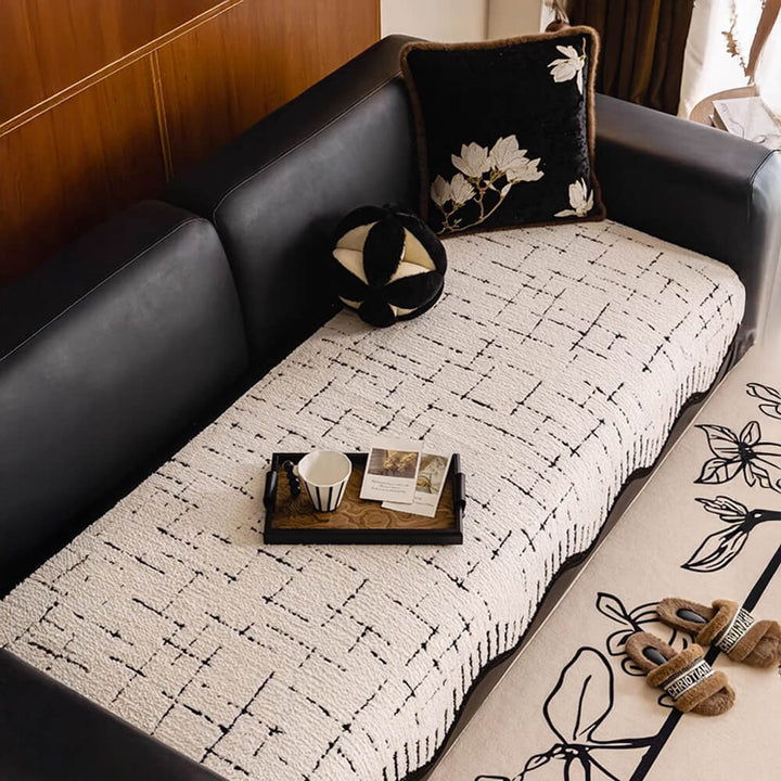 Full view of a living room couch covered with a soft, wave-edged plush protector.