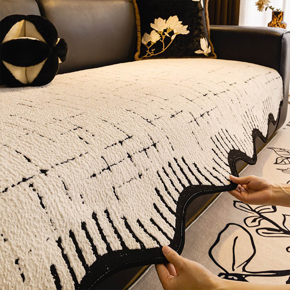 Living room sofa protected by a soft plush cover with decorative wave edges.