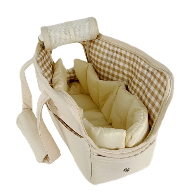 Small white dog comfortably resting inside a well-ventilated, soft-sided travel carrier with zipper top